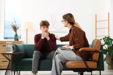 Ofiste genç bir çocukla çalışan profesyonel psikolog.