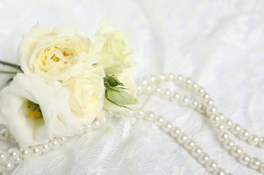 Beautiful flowers and pearls on lace fabric, closeup
