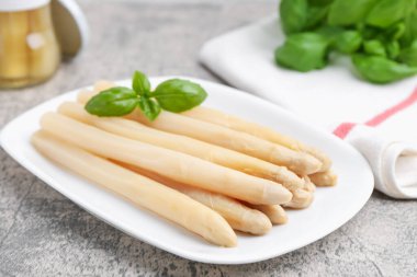 Gri masadaki fesleğenli kuşkonmaz mızrakları yakın plan.