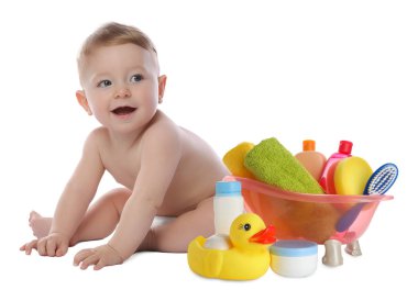 Sevimli küçük bebek, banyo aksesuarları ve bembeyaz tuvalet eşyaları.