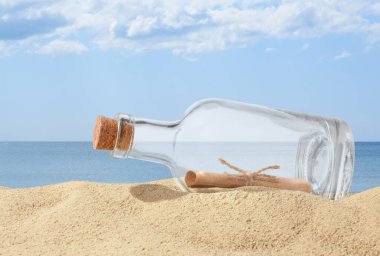 Denize yakın kumda yuvarlanmış mektupla mantar şişesi.