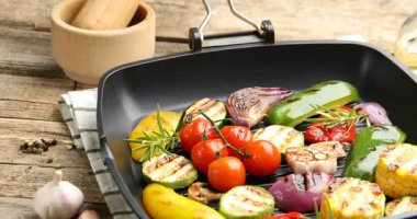 Ahşap masada ızgara sebze ve baharatlı tava, yakın plan. Kamera hareket ediyor