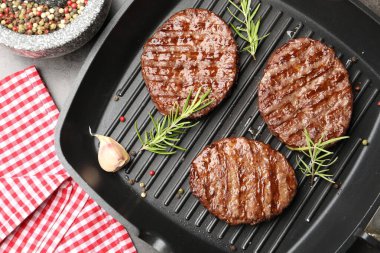 Gri masada ızgara köfteli ve baharatlı tava.