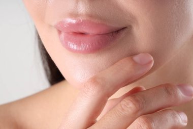 Açık gri arkaplanda güzel dudaklı bir kadın, makro manzaralı.