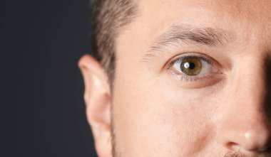 Siyah arka planda güzel gözleri olan adam, yakın plan. Metin için boşluk