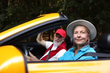 Üst düzey bir çift açık havada eğleniyor, seçici bir odak noktası var.