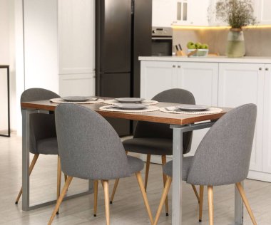 Mutfak içi yemek masası, yer ve gri sandalyelerle dolu.