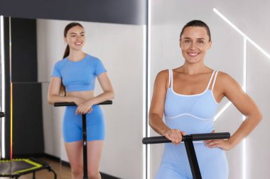 Spor salonundaki trambolinde gülümseyen kadınlar.