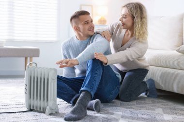 Evde elektrikli ısıtıcının yanında mutlu bir çift var.