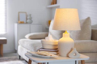 Süslü lamba, dekor ve beyaz masa üzerine kitap.