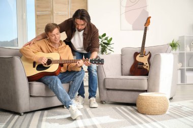 Öğretmenim evde gitar çalmayı öğretiyor.