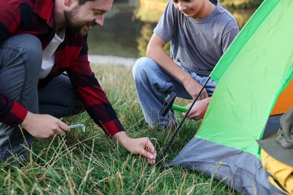 Baba ve oğul kamp çadırı kuruyor, kapatıyorlar.