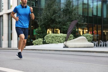 Spor giyimli bir adam dışarıda koşuyor, yakın plan. Metin için boşluk