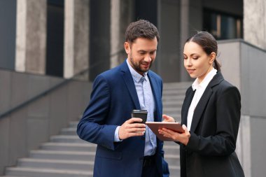 Paket kahve. Açık havada buluşurken kağıt bardak içen bir adam ve iş ortağı, mesaj atmak için yer.