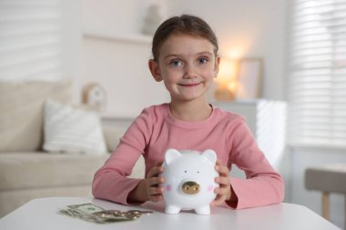 Cep harçlığı ve kumbarası olan küçük bir kız.