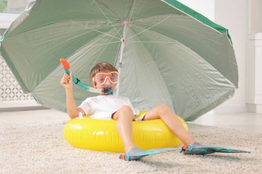 Denizde tatilin hayalini kuruyorum. Dalış maskeli küçük çocuk, şnorkel, palet ve kapalı alanda şişme yüzük.