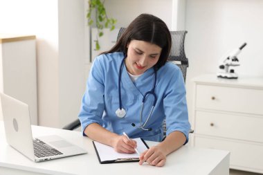 Klinikteki beyaz masada çalışan hasta bakıcı.