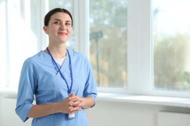 Pencerenin yanında üniformalı hemşire, mesaj için yer var.