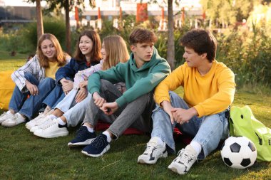 Bir grup genç parkta birlikte vakit geçiriyorlar.