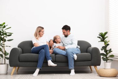 Mutlu aile evdeki kanepede birlikte vakit geçiriyor.