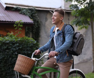 Şehir caddesinde bisiklet süren mutlu bir adam.