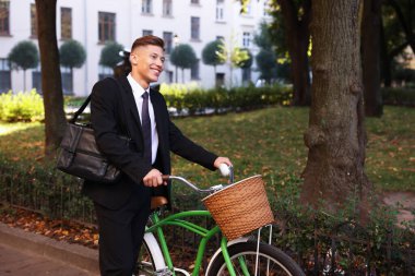 Şehir caddesinde bisiklet süren takım elbiseli bir adam. Metin için boşluk