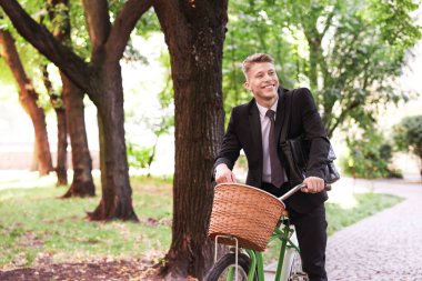 Şehir caddesinde bisiklet süren takım elbiseli bir adam. Metin için boşluk
