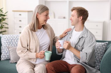 Mutlu oğlu ve annesi evdeki kanepede birlikte vakit geçiriyorlar.