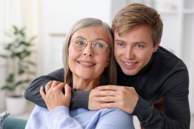 Gülümseyen oğul evde annesine sarılıyor. Aile bağı