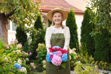 Bahçesinde güzel bir buket çiçekle son sınıf öğrencisi.