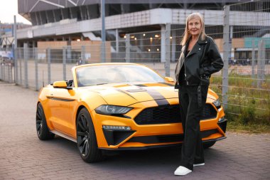 Modern Cabriolet yakınlarında şık bir son sınıf öğrencisi.