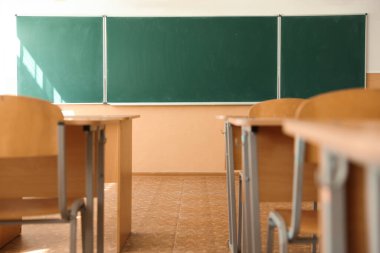 Sınıfta sandalyeli ve yeşil karatahtalı masalar