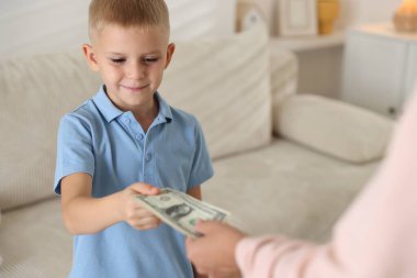 Anne evdeki oğluna harçlık veriyor, yakın plan.