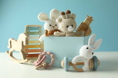 Beyaz masada açık mavi arka planda farklı sevimli oyuncaklar