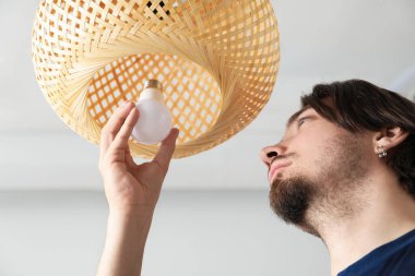 Evdeki ampulü değiştiren adam, düşük açılı görüş.