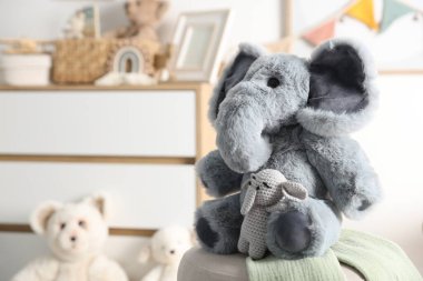 Çocuk odasında puf üzerinde sevimli oyuncak filler, yakın plan. Metin için boşluk