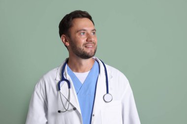 Yeşil arka planda steteskobu olan çocuk doktorunun portresi.