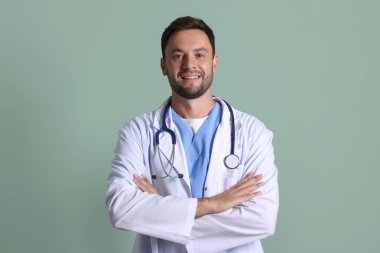 Yeşil arka planda steteskobu olan çocuk doktorunun portresi.