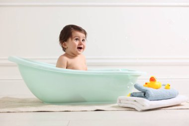 Evde küvette banyo yapan şirin bir bebek.