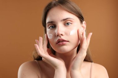 Yüzünde krem lekesi olan güzel bir kadın, yakın plan.