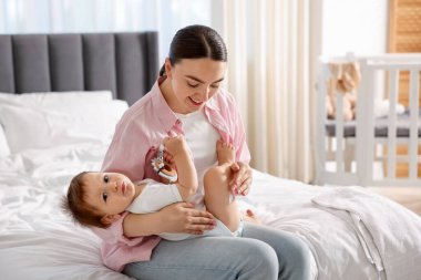 Evde bacağında krema olan anne ve bebek. Metin için boşluk