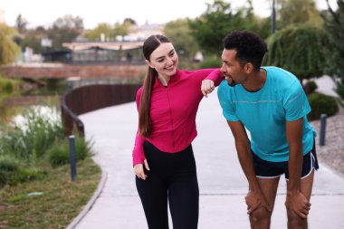 Gülümseyen koşucular dışarıda dinleniyor. Metin için boşluk