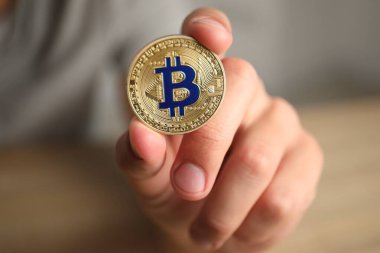Kripto para birimi. Bulanık arka planda altın Bitcoin tutan adam, yakın plan