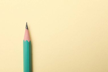 Bej arka planda keskin bir grafit kalem, üst manzara. Metin için boşluk