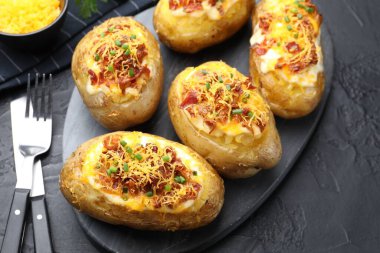 Siyah desenli masada servis edilen lezzetli fırında patatesler, yakın plan.