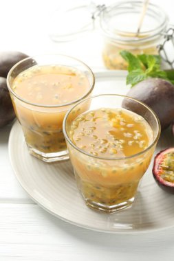 Lezzetli meyve suyu ve beyaz ahşap masada taze meyveler, yakın plan.