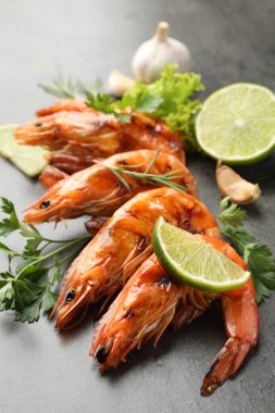 Tasty grilled shrimps with spices on grey table, closeup. Delicious seafood dish