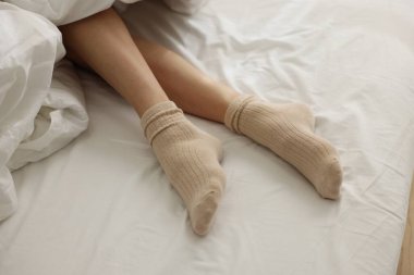 Beyaz çarşaflı çoraplı kadın, yakın plan.