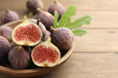 Tahta masada taze incir ve yeşil yaprak, yakın plan. Metin için boşluk