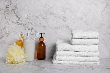 Mermer masa üzerinde beyaz havlu ve tuvalet malzemeleri yığını